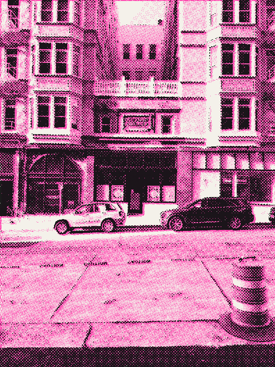 The same two stone buildings, closer, with caution tape across the street