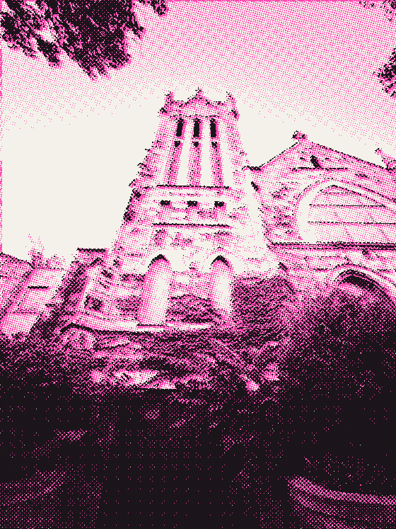 A stone church tower seen from below through trees