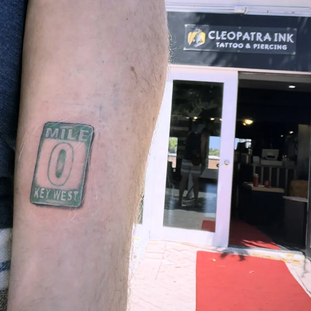 A fresh Mile 0 Key West tattoo on Aaron's leg outside Cleopatra Ink