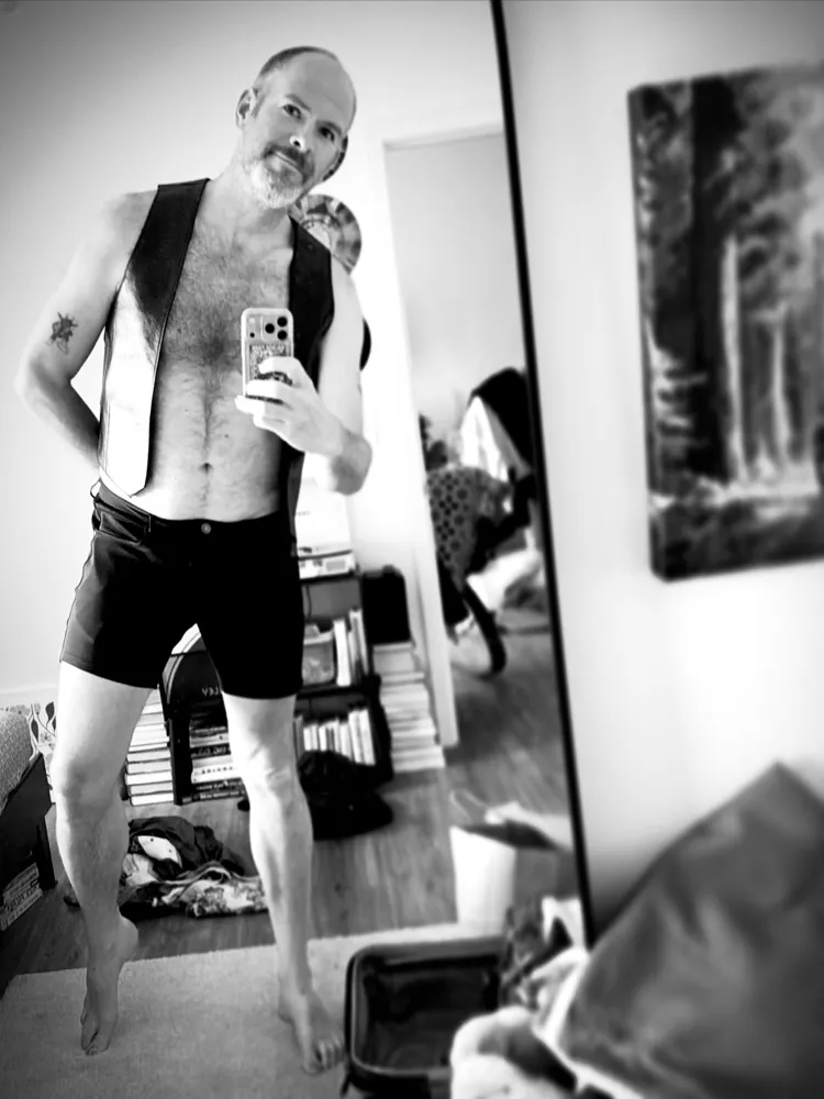 Aaron's black-and-white mirror selfie in a leather harness at Leatherwerks