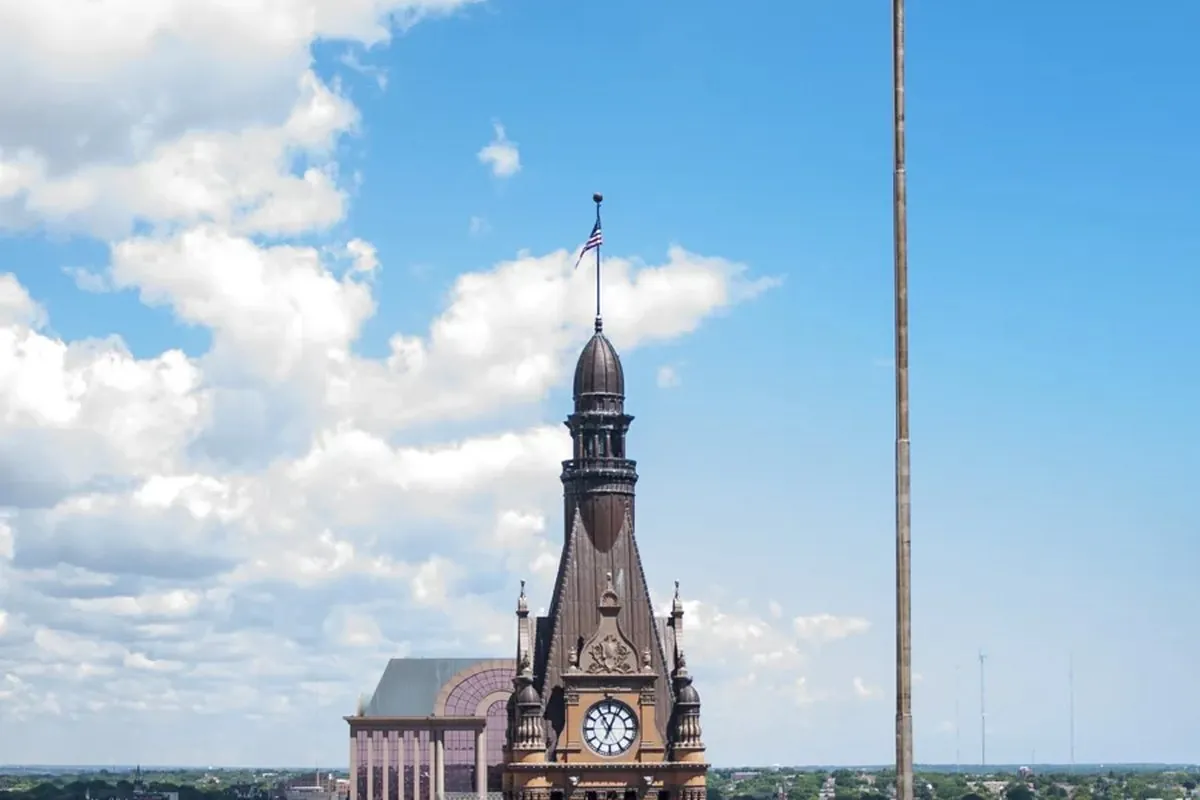 Milwaukee City Hall tower and the city flag against a blue sky