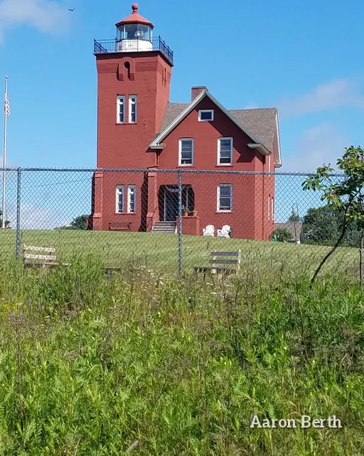 A red brick lighthouse keeper's house in a green field