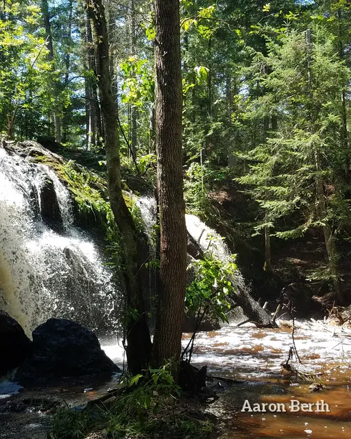 A waterfall dropping through a green forest at Amnicon Falls