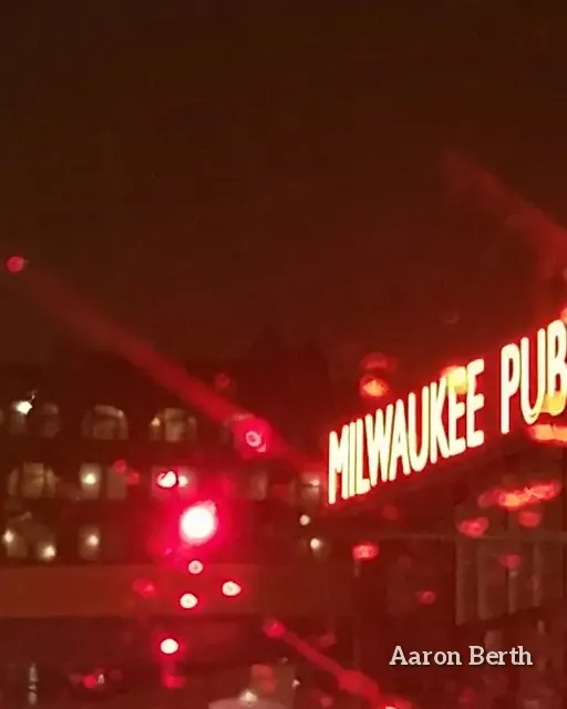 The red neon Milwaukee Public Market sign glowing against a night sky