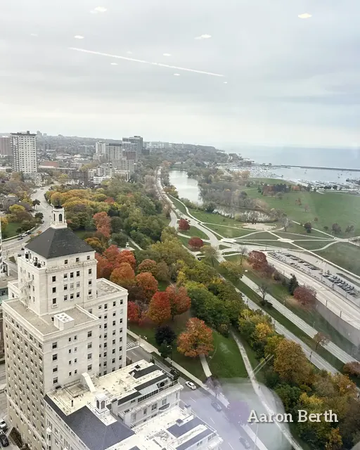 An aerial view of the Milwaukee lakefront, towers and a river valley in fall color