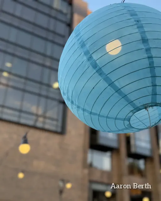A glass-front building with a big blue paper lantern hanging in front