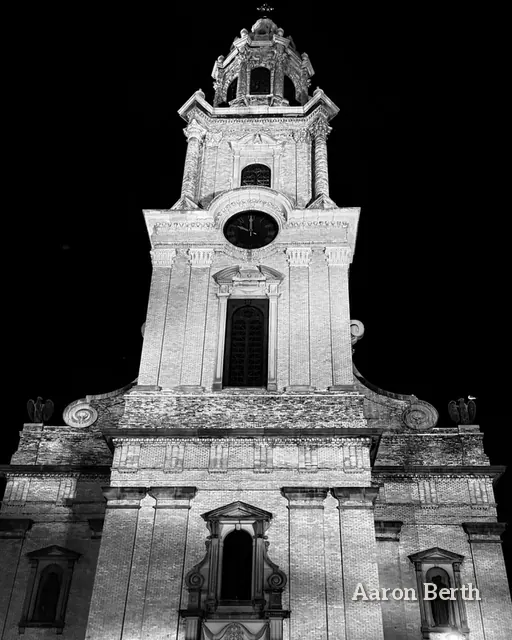Black and white: a church tower lit against a black sky