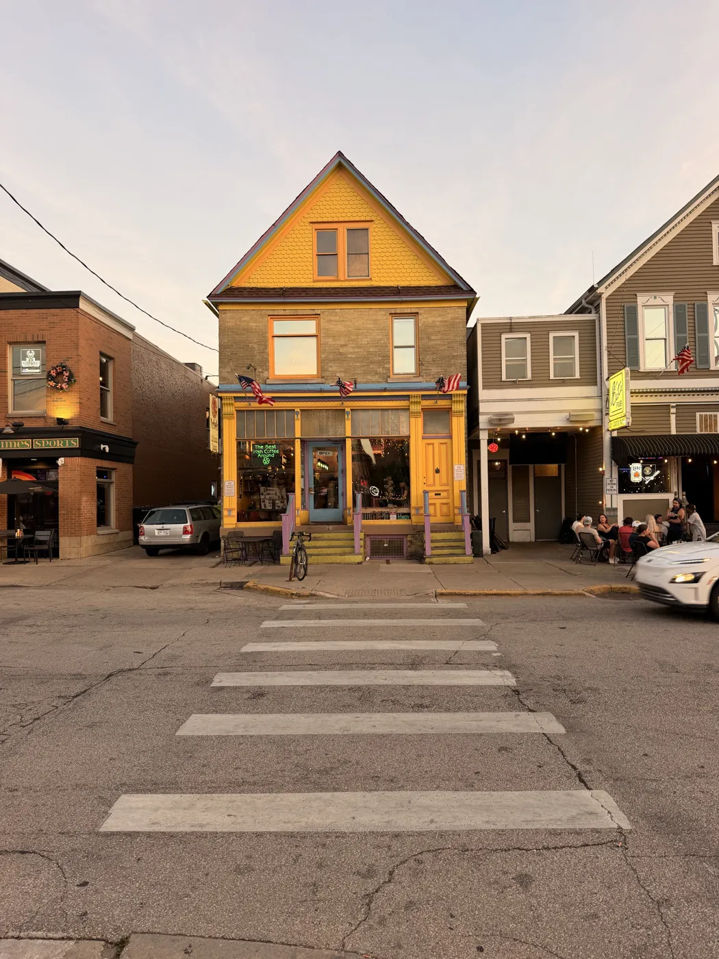 A yellow storefront house at the end of a Brady Street crosswalk