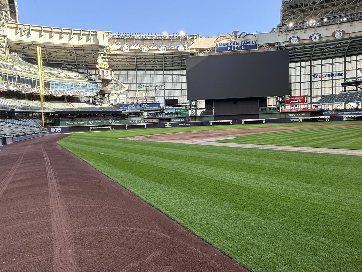 The ballpark grass up close, with the stands behind it