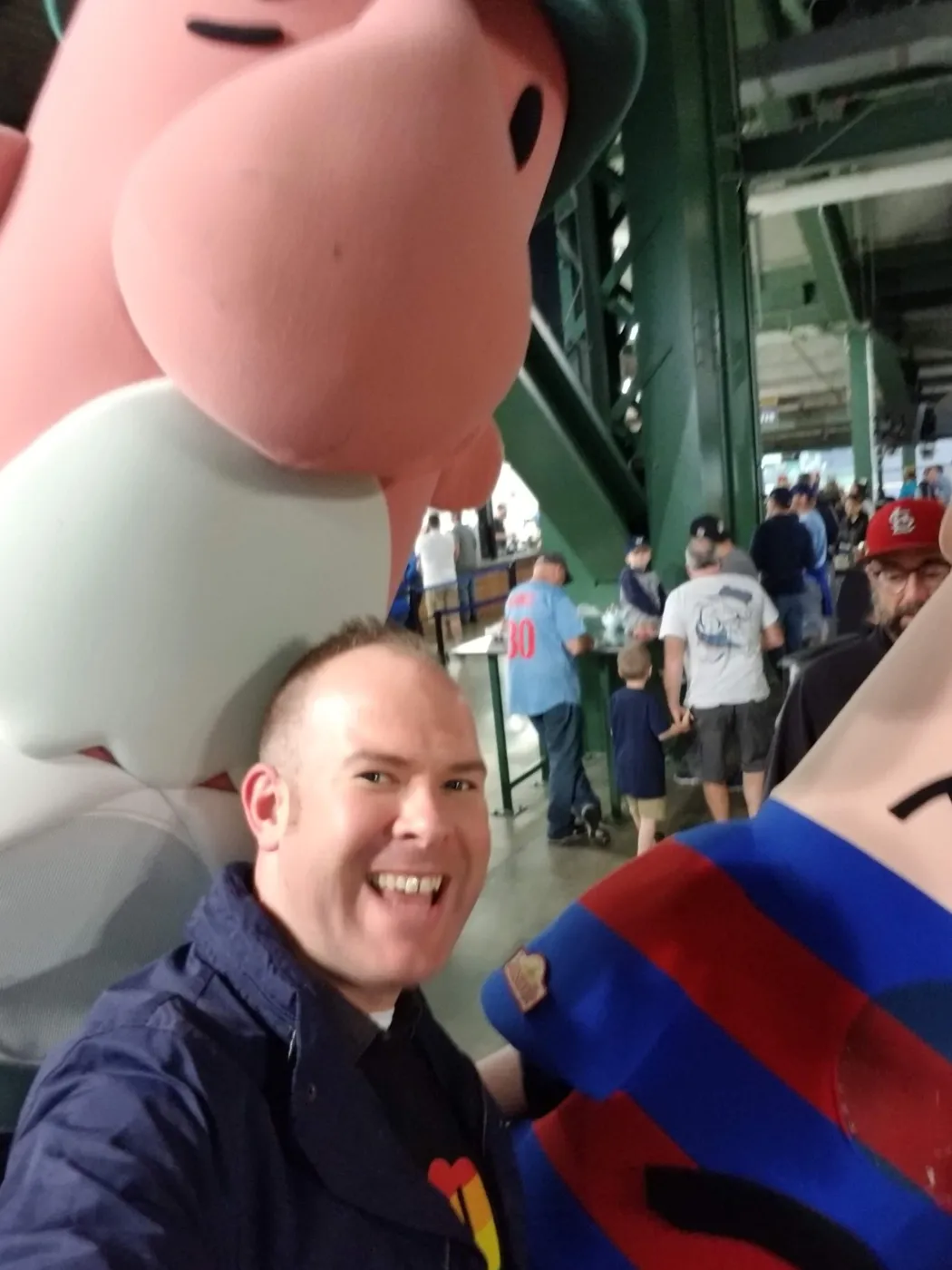 Aaron Berth grinning in a selfie with a racing sausage mascot at the ballpark