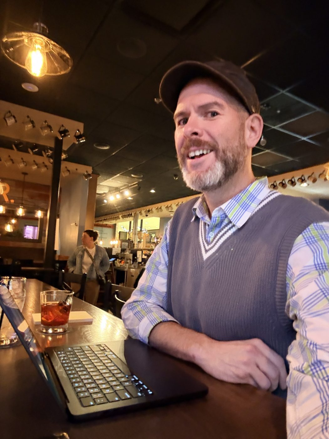 Aaron working on a laptop at a bar